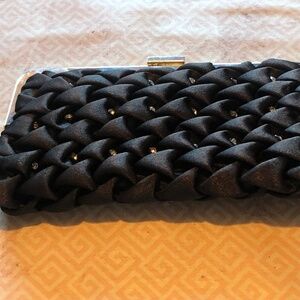 Black quilted like clutch, with metal snap closure, pearls, , chain and bling.